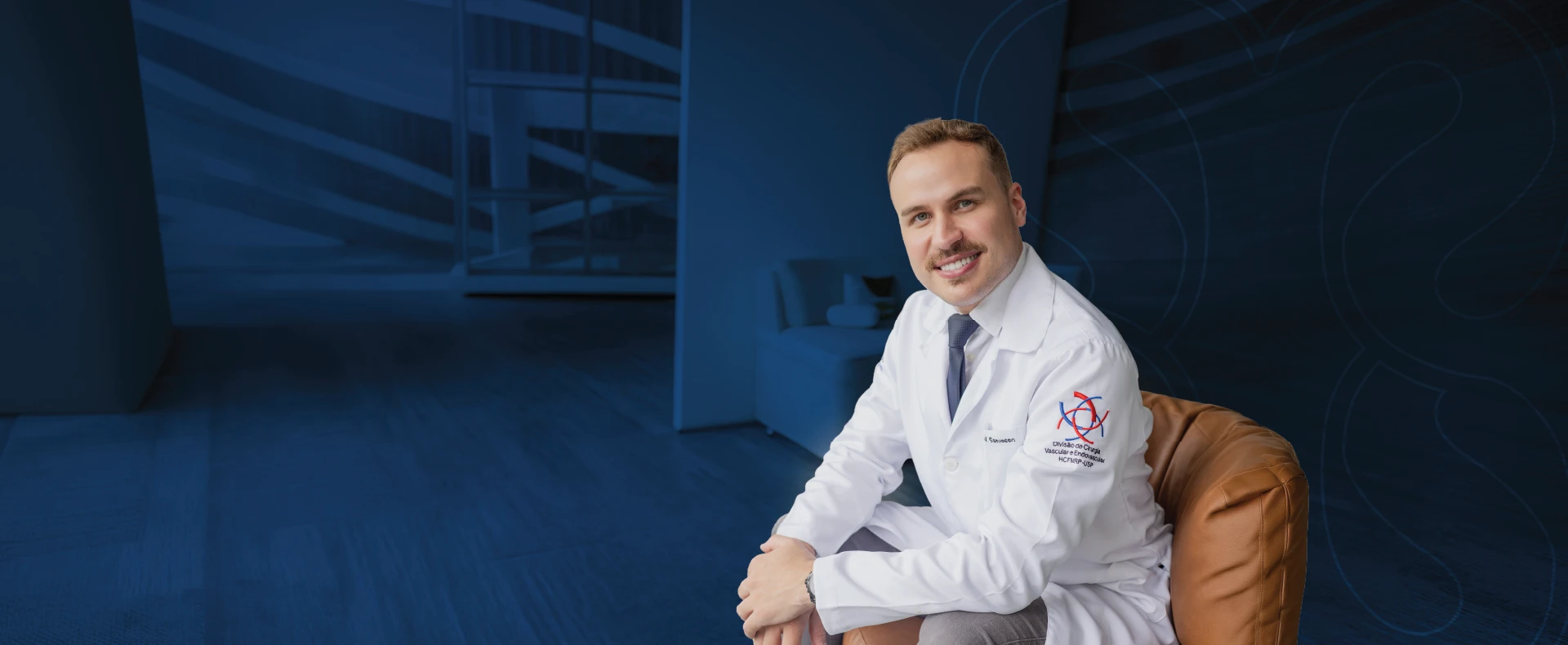 Dr. Eduardo Sanvesso, cirurgião vascular, sorrindo em consultório